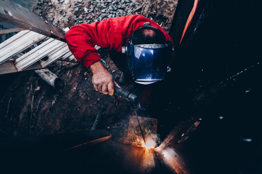 man welding a metal frame with sparks
